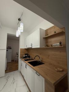 a kitchen with white cabinets and a sink at Harmony Suite Apartment in Pápa