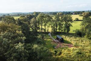 an aerial view of a field with trees and a house at Adhara in Tarporley