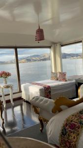 a bedroom with two beds and a view of the water at Amalia Titicaca Lodge in Puno