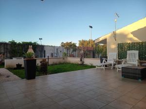 a patio with white chairs and a yard at Tropea's green terrace in Tropea