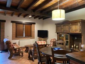 a living room with a table and chairs and a tv at La Helguera By Silastur in Colombres