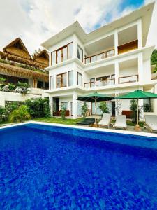 a house with a swimming pool in front of it at Garden Hill Views in Kuta Lombok