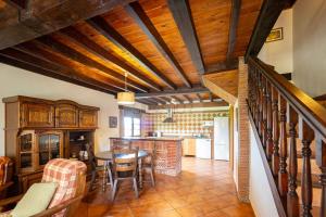 a kitchen and dining room with wooden ceilings and a table at La Helguera By Silastur in Colombres