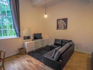 a living room with a couch and a television at Stylish Edinburgh Studio in Edinburgh