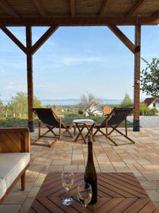a patio with a table and two glasses of wine at Haptapta House in Balatonudvari