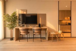 a living room with a desk with a tv and chairs at OPUS Batumi in Batumi
