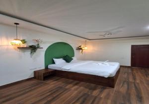 a bedroom with a large bed with a green headboard at Temple Tree Homes in Bangalore