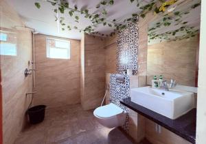 a bathroom with a sink and a toilet in it at Temple Tree Homes in Bangalore