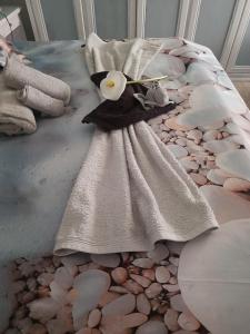 a bed with a dress and two flowers on it at Villa Ornella in Luni +36 photos