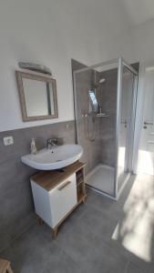 a bathroom with a sink and a shower at Ferienwohnung Melle - Westerhausen in Melle +1 photo