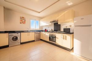 a kitchen with white cabinets and a washer and dryer at Atlantic Blue 3BR Ocean View, Rabat Corniche in Rabat