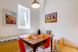 a dining room with a table and red chairs at GuestHost - Arkè Colorful Apartment in Giuggianello +14 photos
