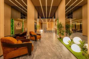 a lobby of a hotel with couches and plants at OPUS Batumi in Batumi