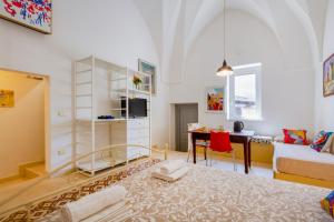 a living room with a bed and a desk in a room at GuestHost - Arkè Colorful Apartment in Giuggianello