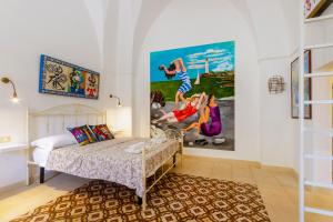 a bedroom with a bed and a painting on the wall at GuestHost - Arkè Colorful Apartment in Giuggianello