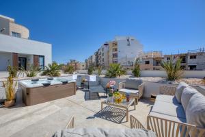 a patio with couches and chairs on a rooftop at 6BR luxury villa with Pool & Hot tub - 2Living rooms & 10Bathrooms in Tal-Għoqod