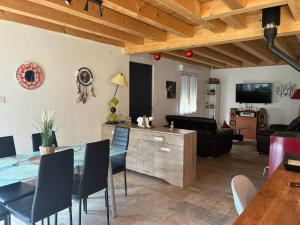 a dining room and living room with a table and chairs at Chalet de montagne, très confortable, neuf in LʼArgentière-la-Bessée