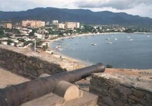 a cannon on a wall next to a body of water at Espartan Lux Juan Griego in Juangriego