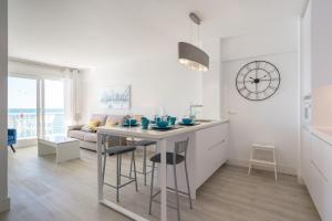 a kitchen and living room with a table and a clock at Espartan Lux Juan Griego in Juangriego