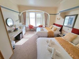 a hotel room with two beds and a mirror at OYO Lily Hotel Blackpool in Blackpool
