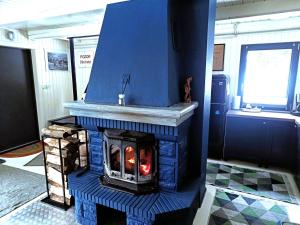 a fireplace in a room with a blue wall at Modry Domek Szczyrk domek na wyłączność z kominkiem in Szczyrk