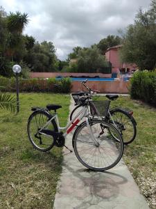 a bike is parked on a sidewalk in the grass at Casa Ady in San Teodoro +13 photos