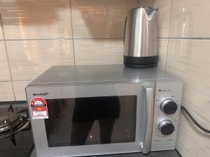 a microwave with a coffee maker on top of it at Sungai palas Horizon in Cameron Highlands