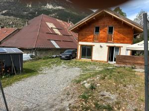 a house with a car parked in front of it at Chalet de montagne, très confortable, neuf in LʼArgentière-la-Bessée