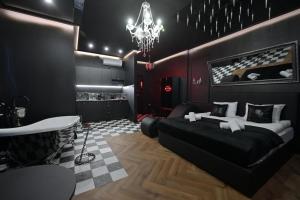 a bedroom with a black bed and a chandelier at Love Krak-Off - BDSM Old Town in Krakow