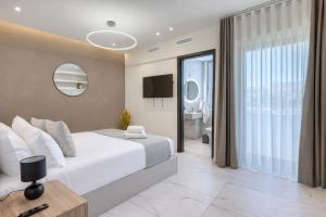 a bedroom with a large white bed and a mirror at 6BR luxury villa with Pool & Hot tub - 2Living rooms & 10Bathrooms in Tal-Għoqod +291 photos