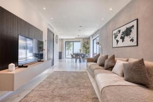 a living room with a large couch and a television at 6BR luxury villa with Pool & Hot tub - 2Living rooms & 10Bathrooms in Tal-Għoqod
