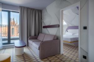 a room with a couch and a bed and a mirror at Prize by Radisson, Gdansk in Gdańsk