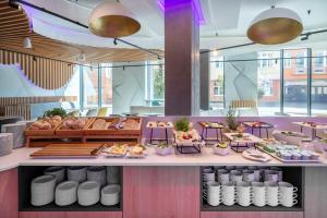 a restaurant with tables and plates of food at Prize by Radisson, Gdansk in Gdańsk