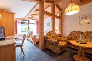 a living room with a couch and a table at Hotels am Kranichsee in Hahnenklee-Bockswiese