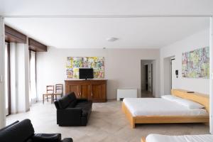 a bedroom with a bed and a couch and a chair at Aparthotel All'Orologio in Peschiera del Garda +99 photos