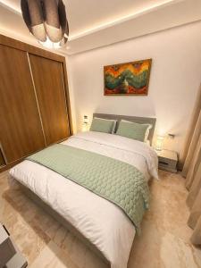 a bedroom with a bed and a painting on the wall at Appt lux Hammamet Nabeul in Hammamet Nord
