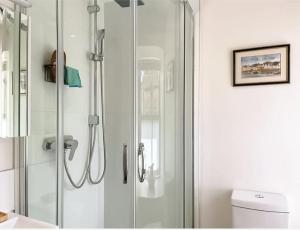 a shower with a glass door in a bathroom at Borders Cottage in Coldstream +12 photos