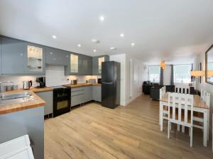 a kitchen and dining room with a black refrigerator at Borders Cottage in Coldstream
