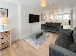 a living room with a couch and a tv at Borders Cottage in Coldstream