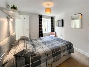 a bedroom with a bed and a mirror at Borders Cottage in Coldstream