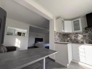 a kitchen with white cabinets and a table in a room at Maison entière in Dax