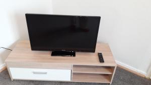 a flat screen tv sitting on top of a wooden stand at Apartment Jackie 2 in Bielefeld