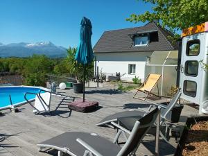 a patio with chairs and an umbrella and a pool at Casa Lieselotte in Velden am Wörthersee