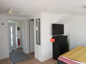 a bedroom with a bed and a tv on a wall at Casa Lieselotte in Velden am Wörthersee