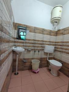 a bathroom with a toilet and a sink at Pinewood Sunrise Homestay Kasauli by Splendid Retreat Hotels in Kasauli