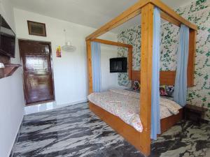 a bedroom with a bed with a wooden frame at Pinewood Sunrise Homestay Kasauli by Splendid Retreat Hotels in Kasauli +18 photos