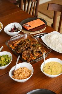 a table topped with dishes of food and rice at Ranna Beach House in Ranna