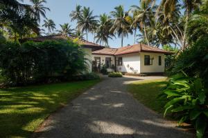 a house with palm trees in front of a driveway at Ranna Beach House in Ranna