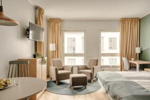 ein Hotelzimmer mit Bett, Tisch und Stühlen in der Unterkunft The Nooq Lund - Hotel & Studios in Lund