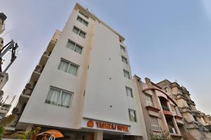 a tall white building with a sign on it at Nova Yashraj Hotel in Rajkot